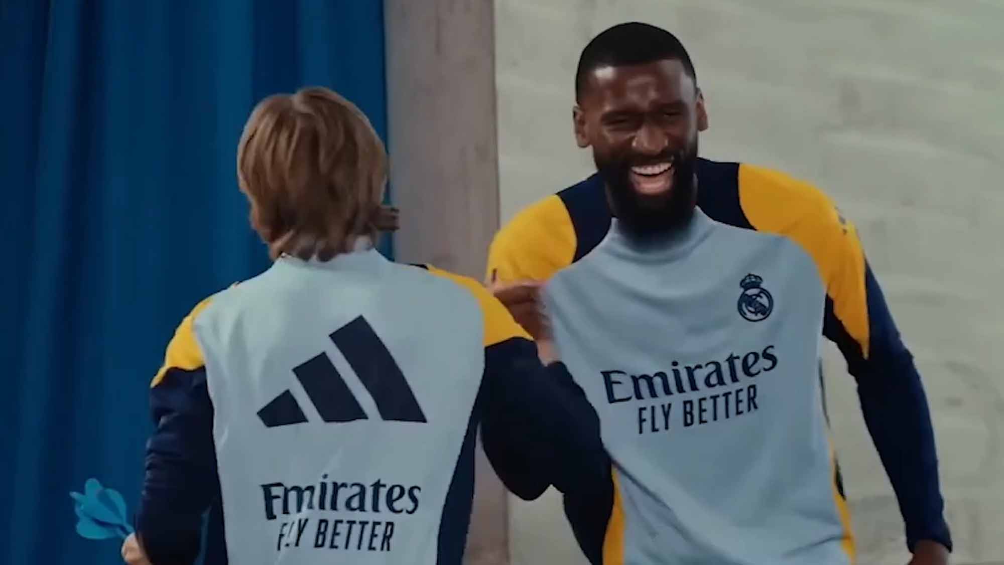 Rüdiger riendo con Modric dándose la mano