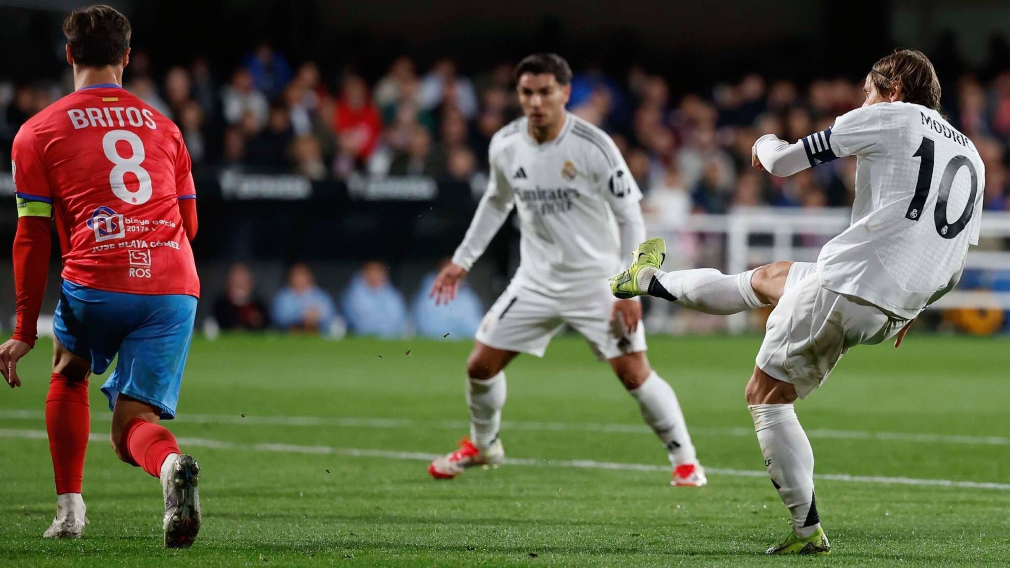 Luka Modric golpea un balón, ante la atenta mirada de Brahim Díaz, en el encuentro de este lunes ante la Deportiva Minera en la Copa del Rey.