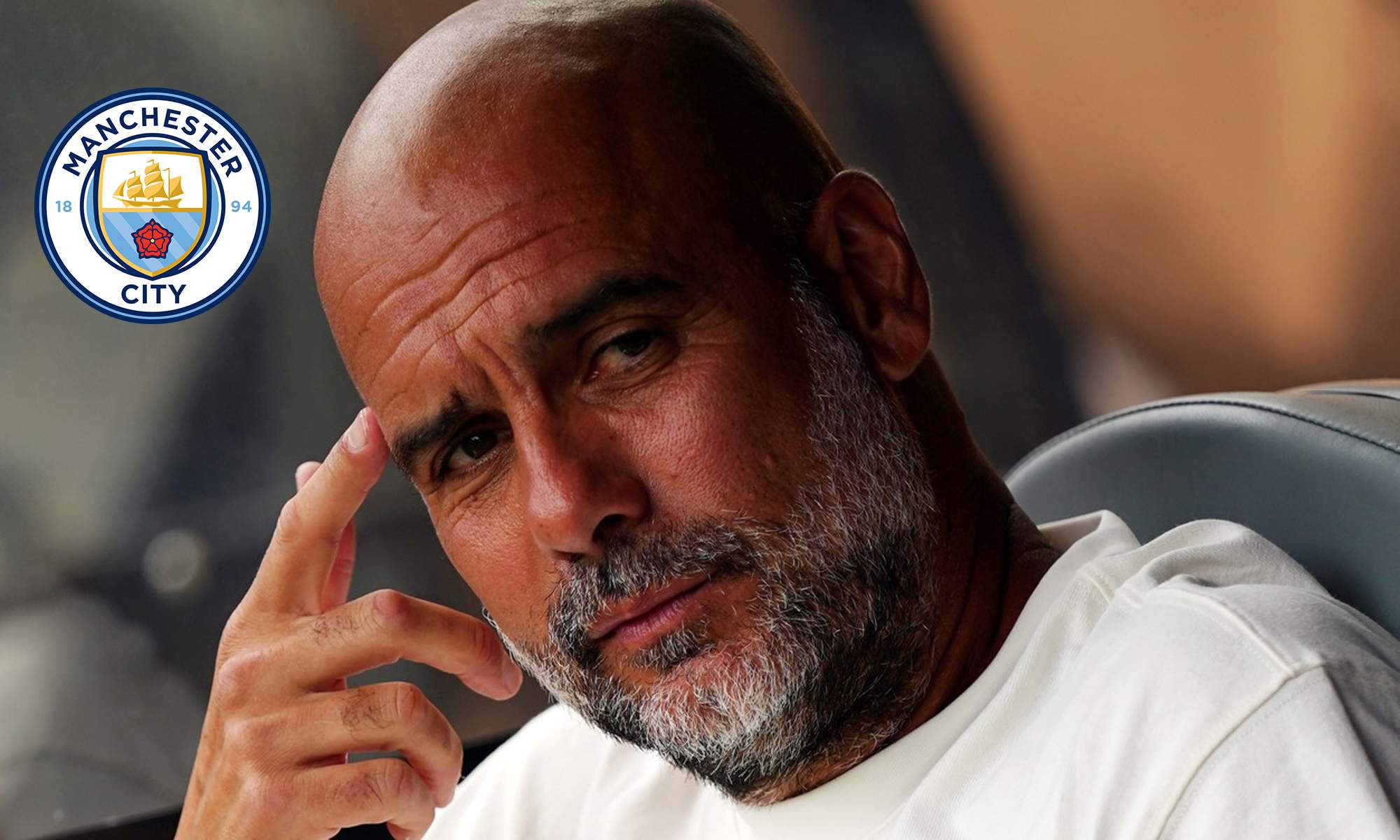 Pep Guardiola y un escudo del Manchester City.