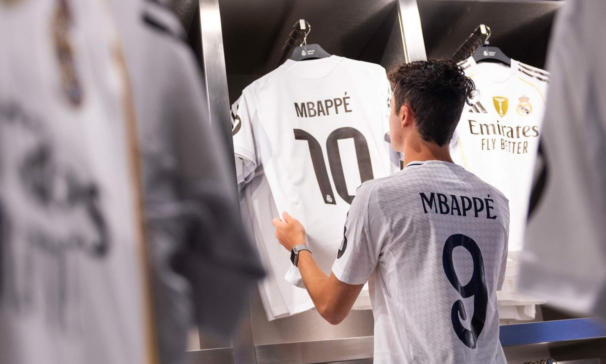 Un aficionado del Real Madrid, contemplando la nueva camiseta del equipo en el dorsal, también nuevo, de Kylian Mbappé.