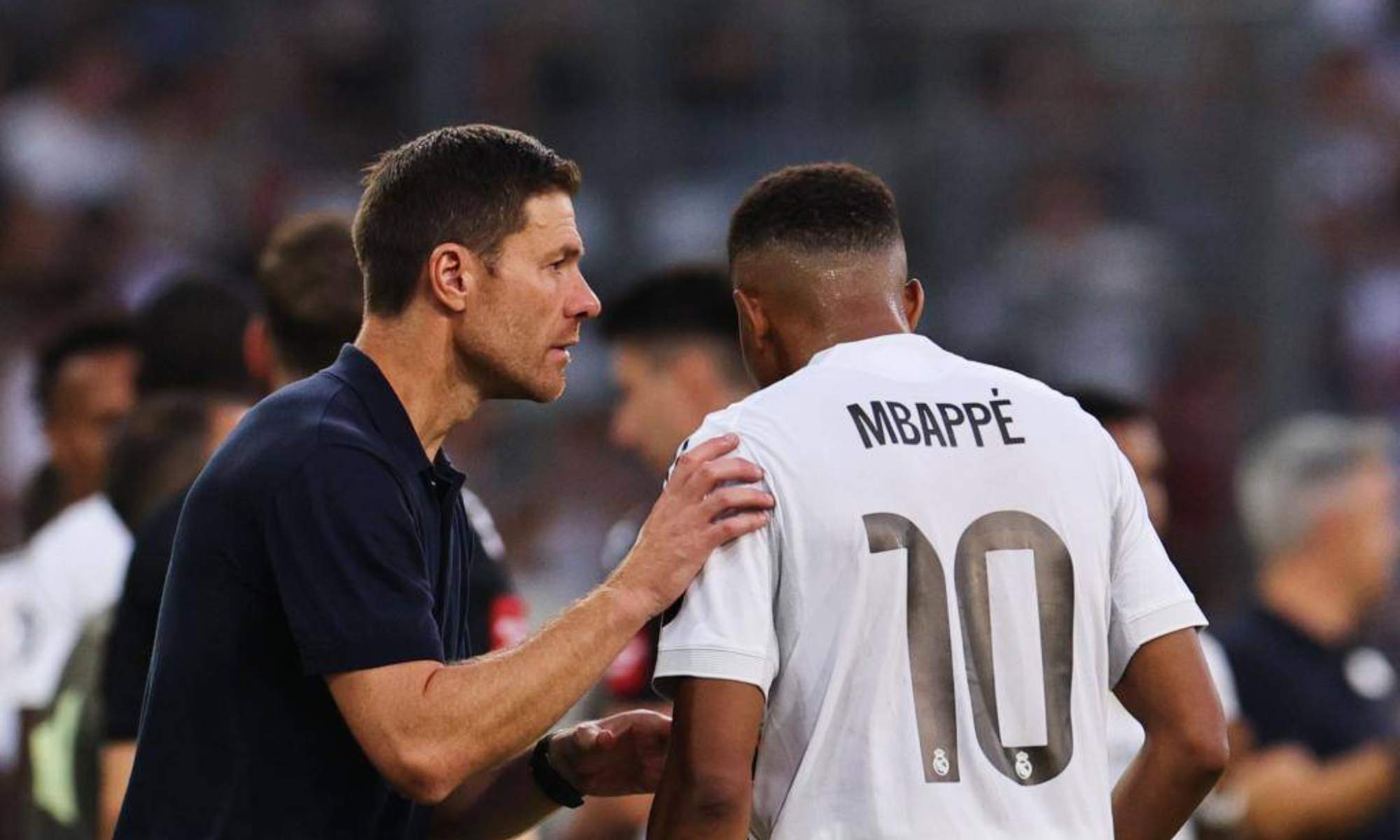 Xabi Alonso, conversando con Kylian Mbappé durante un partido del Real Madrid.