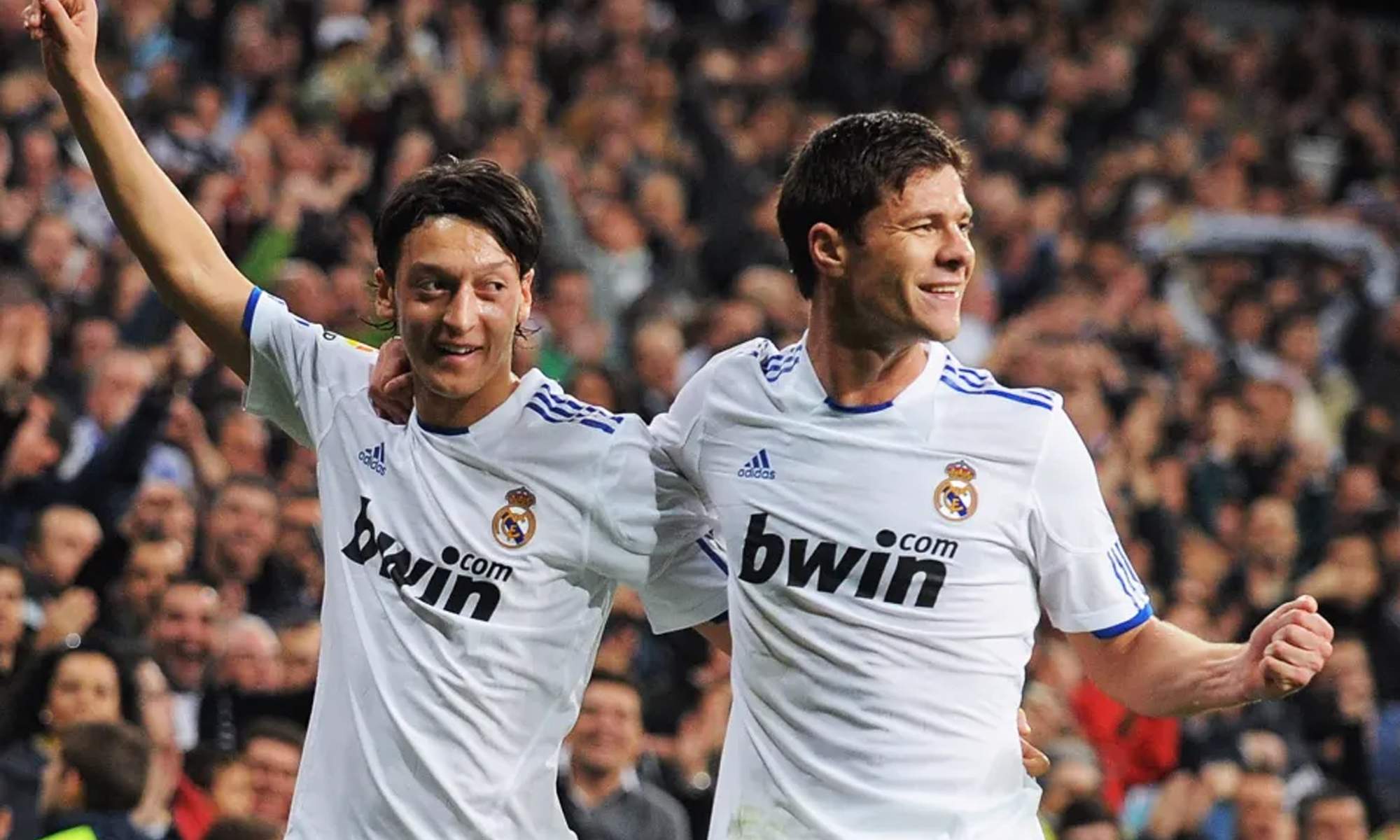 Mesut Özil y Xabi Alonso celebrando un gol con el Real Madrid.