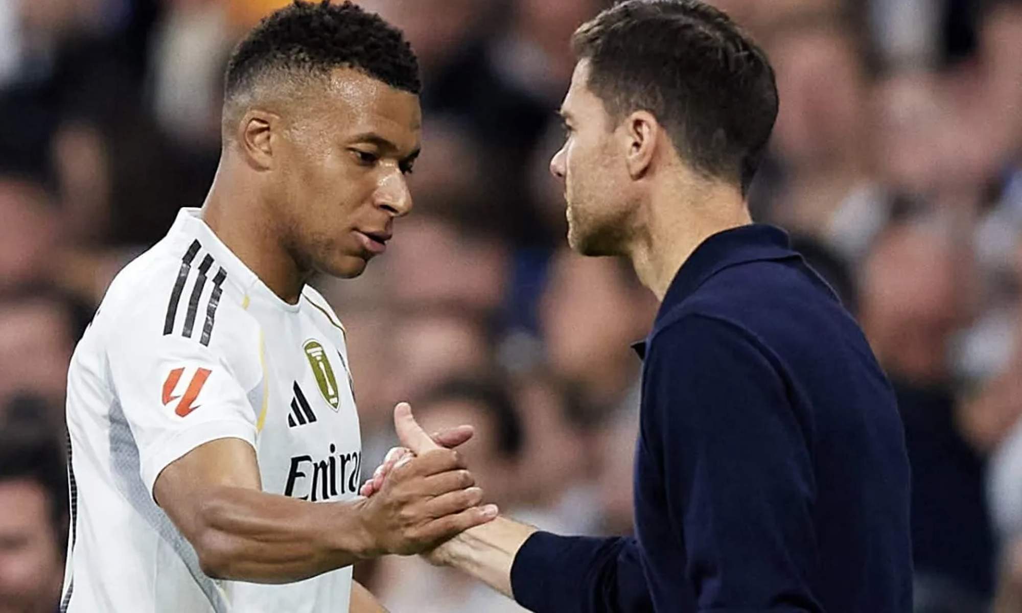 Kylian Mbappé y Xabi Alonso saludándose en un partido del Real Madrid.